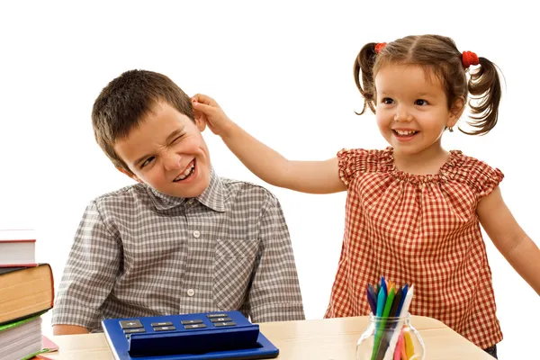 Маленькая девочка держит мальчика за ухо — стоковое фото