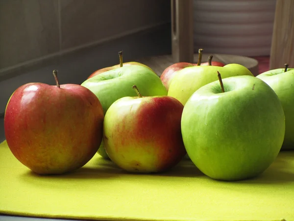 Цветные яблоки на столе — стоковое фото