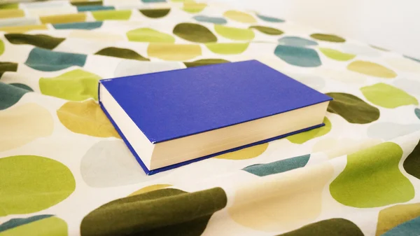 Modrá kniha na postel — Stock fotografie