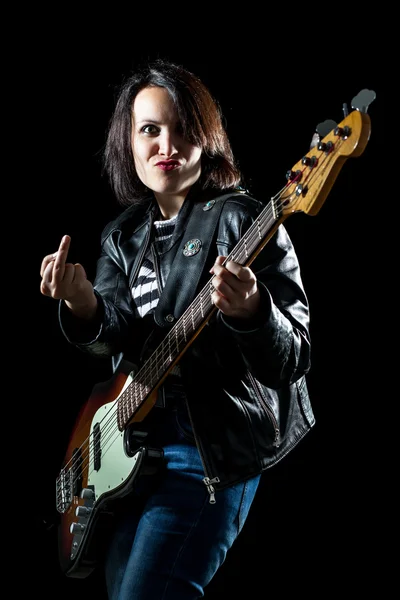 Mulher com guitarra baixo elétrico mostrando dedo médio — Fotografia de Stock