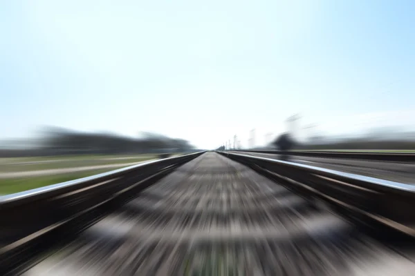 Φωτογραφία του ένα γρήγορο τρένο σε κίνηση και μπλε ουρανό — Φωτογραφία Αρχείου