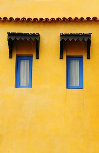 Blaues Fenster an gelber Grunge-Wand — Stockfoto
