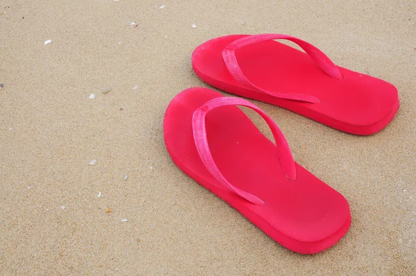 stock image Red slippers on sand