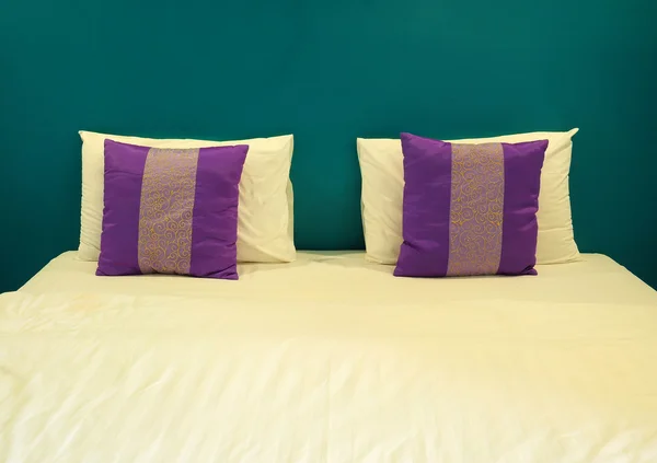 Poduszki białe i fioletowe na białe łóżko — Zdjęcie stockowe