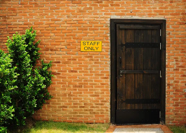 ประตูไม้บนผนังอิฐ — ภาพถ่ายสต็อก