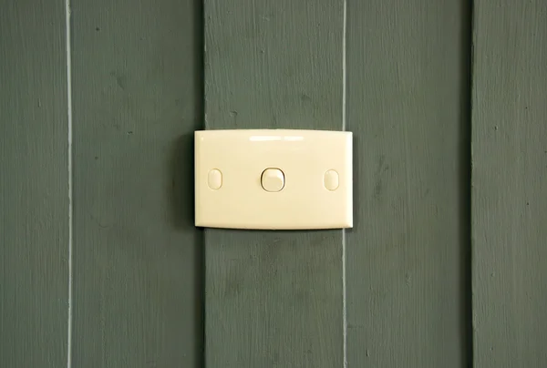 Interruptor branco na parede de madeira verde — Fotografia de Stock