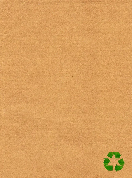 Grünes Recyclingschild auf braunem Papier — Stockfoto