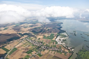 Aerial view of village landscape over clouds clipart