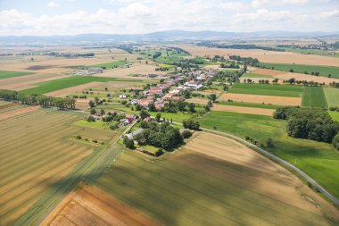 Aerial view of village landscape over clouds clipart