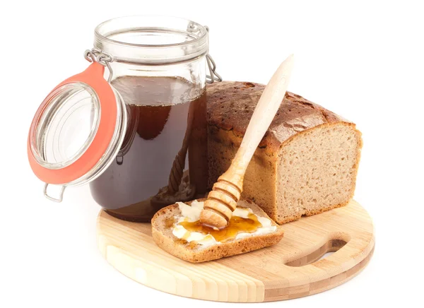 Honey jar and dark bread — Stock Photo, Image