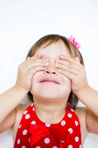 Het kleine meisje bedekt haar ogen met haar handen — Stockfoto