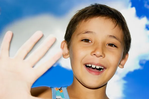Хлопчик посміхається на фоні неба — стокове фото