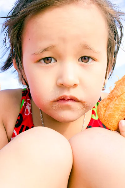 Uma menina come pão — Fotografia de Stock