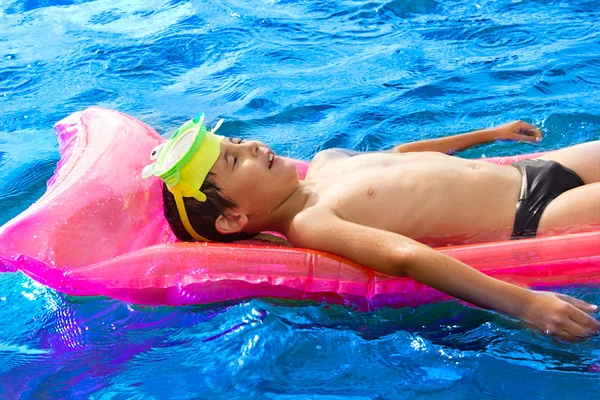 Chłopiec pływanie na wodzie z relaksem Obrazy Stockowe bez tantiem