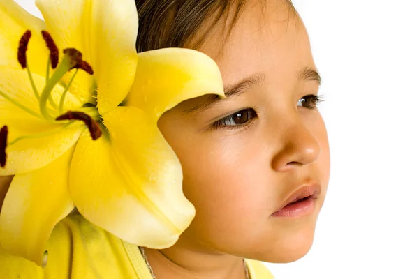 Kleines Mädchen mit einer gelben Lilie im Haar lizenzfreie Stockfotos