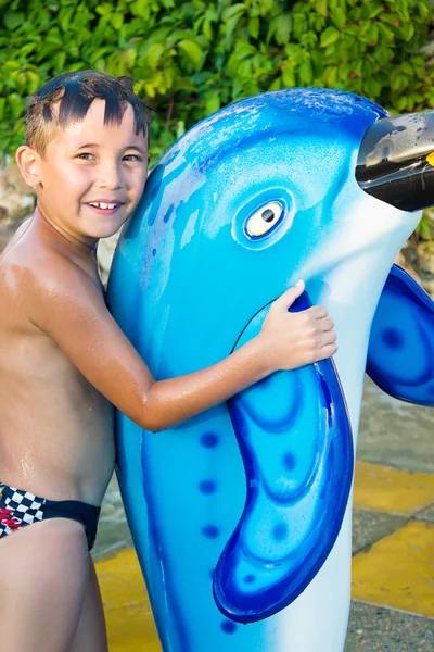 Malý kluk u bazénu s delfínem — Stock fotografie