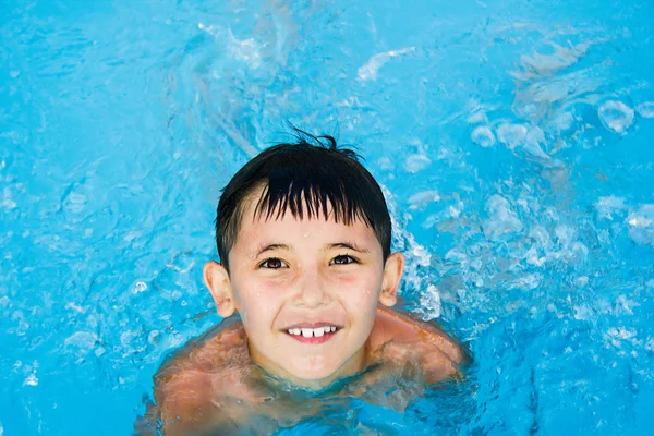 Ein kleiner Junge schwimmt im Wasser — Stockfoto