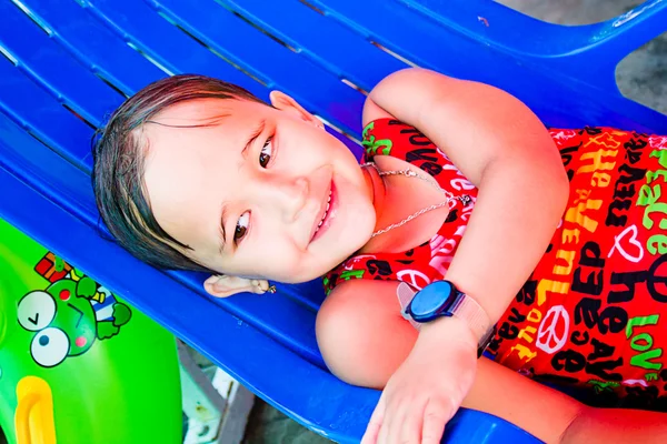 Niña yace en una tumbona junto a la piscina — Foto de Stock