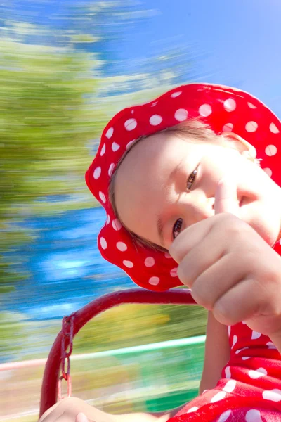Маленькая девочка на карусели с размытым фоном — стоковое фото
