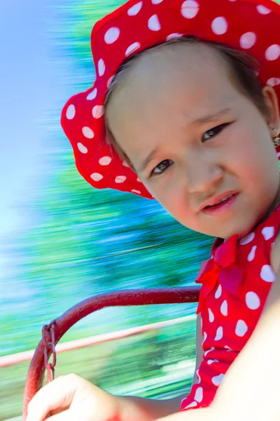 Pieni tyttö karuselli kanssa hämärtynyt tausta — kuvapankkivalokuva