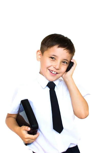 Мальчик держит ноутбук и разговаривает по телефону — стоковое фото