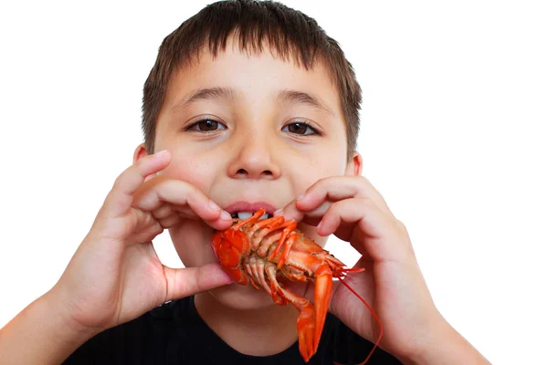 A little boy playfully eating crayfish Stock Picture