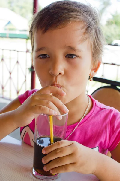 A little girl drinking juice at the cafe — Stock Photo, Image