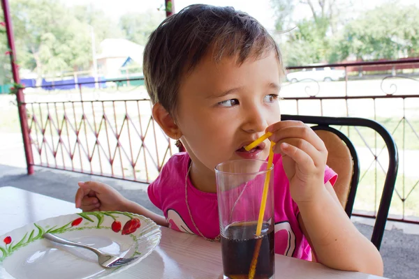 En liten flicka dricka saft på café — Stockfoto