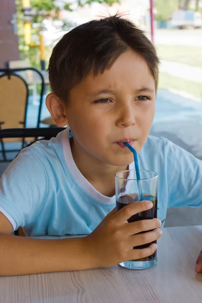 Egy kisfiú, ivás lé a kávézóban — Stock Fotó