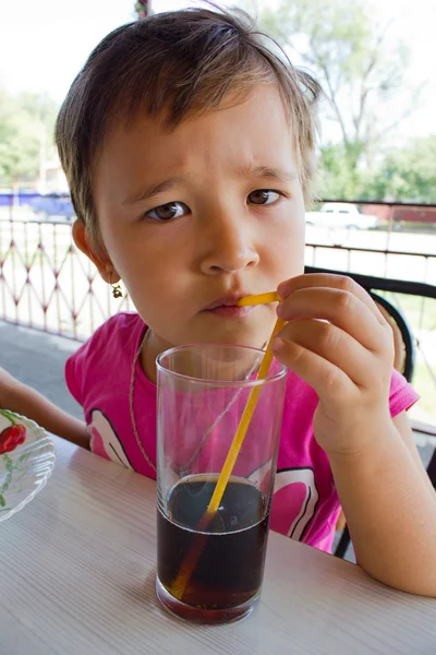A little girl drinking juice at the cafe — Stock Photo, Image