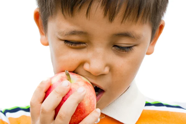 En liten pojke som äter ett äpple — Stockfoto