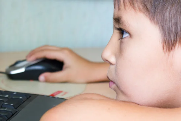 Drengen på trods af træthed spiller på computeren - Stock-foto