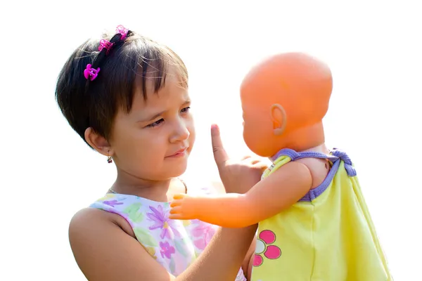 Маленькая девочка учит свою куклу правилам — стоковое фото