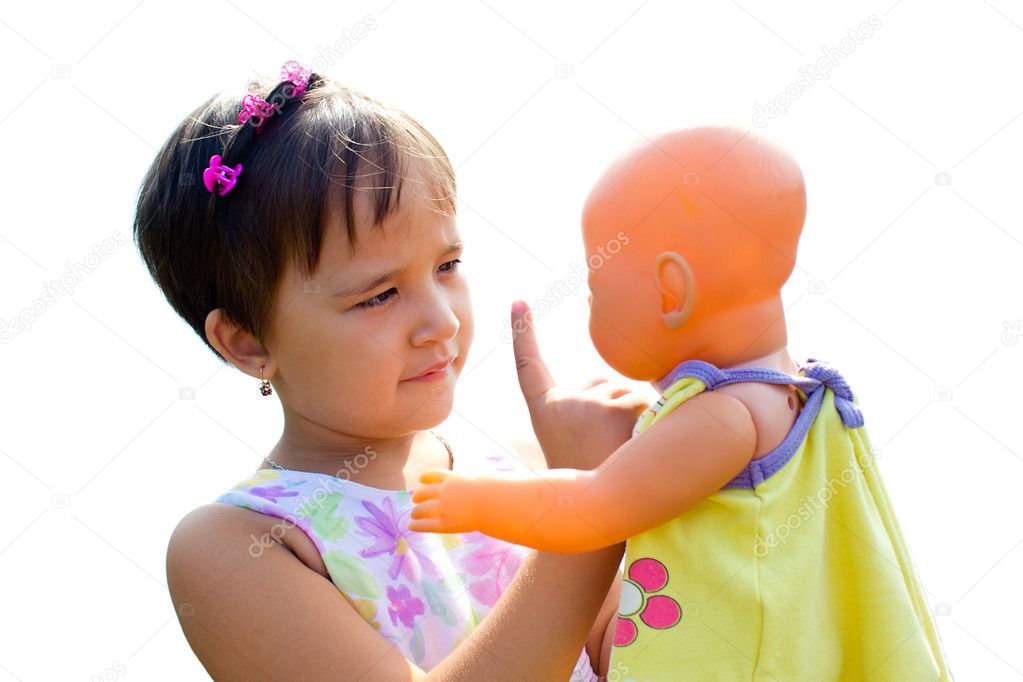 A little girl teaches her doll the rules