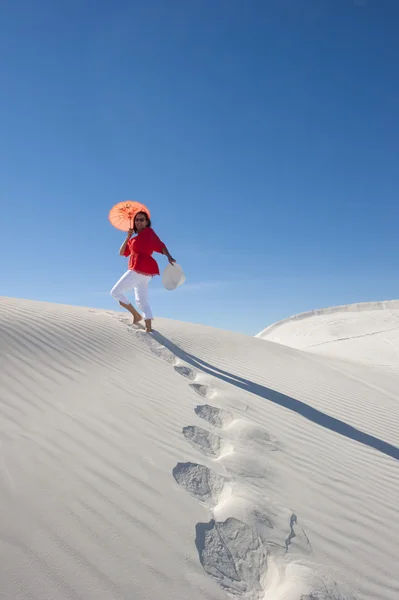Attraktiv kvinna lämnar fotspår upp en sanddune — Stockfoto