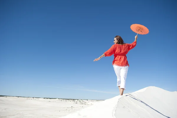 Beautiful mature woman walking on sand dune — Stock Photo, Image