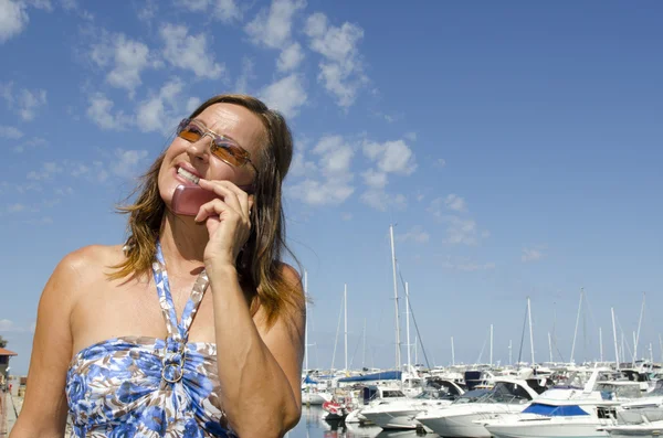 Hezká žena mluvila na mobilním telefonu v marina — Stock fotografie
