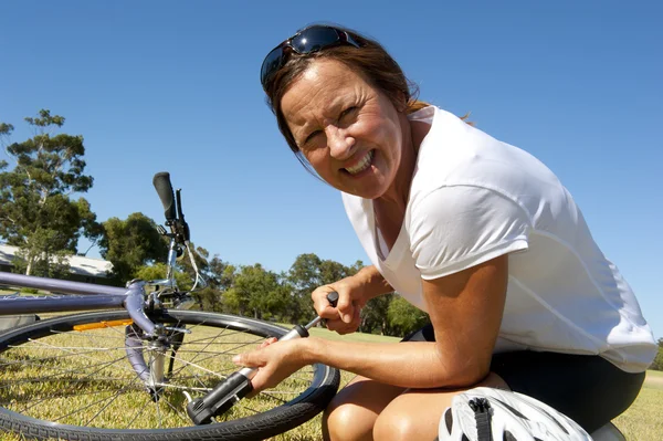 Ciclista femenina reparando bicicleta — Foto de Stock