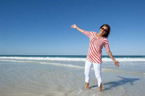 成熟した幸せな健康な女性のビーチでは、運動 — ストック写真
