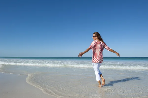 Зрелая счастливая здоровая женщина занимается на пляже — стоковое фото