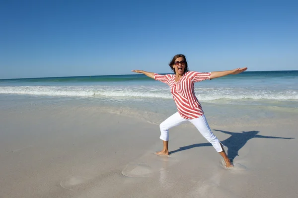在海滩上行使的快乐健康的成熟女性 — 图库照片