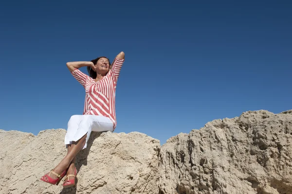 高いヒールの女性孤立岩の上に座って — ストック写真