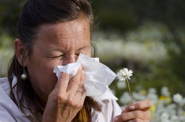 Woman suffering hay fever in field of wildflower clipart