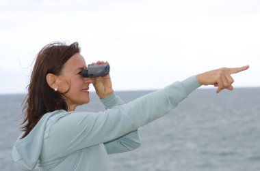 Pretty mature woman with binoculars clipart