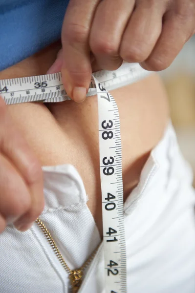 Woman on diet with measuring tape around waist — Stock Photo, Image