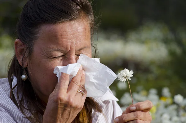 Mulher que sofre de febre do feno no campo de flores silvestres — Fotografia de Stock