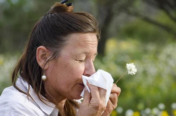 Vrouw lijden hooikoorts op gebied van wildflower — Stockfoto