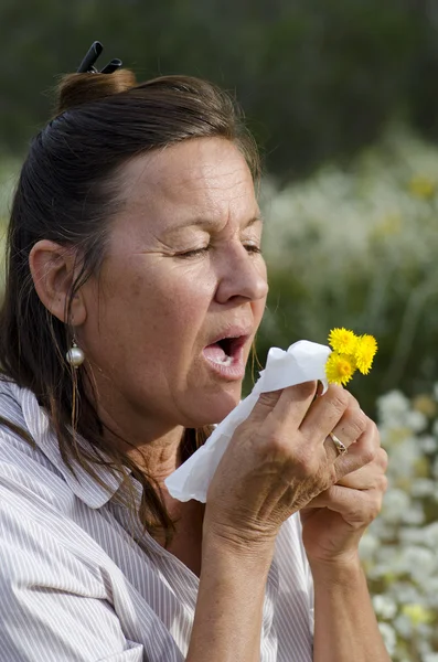 Женщина, страдающая сенной лихорадкой на полях диких цветов — стоковое фото