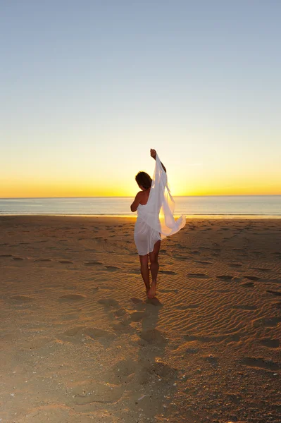 Sexy woman white cloth at sunset beach dancing — Stock Photo, Image