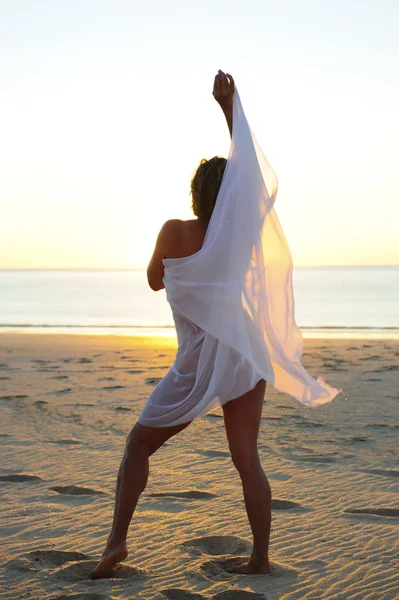 Sexy kobieta białe tkaniny w taniec zachód słońca plaża — Zdjęcie stockowe